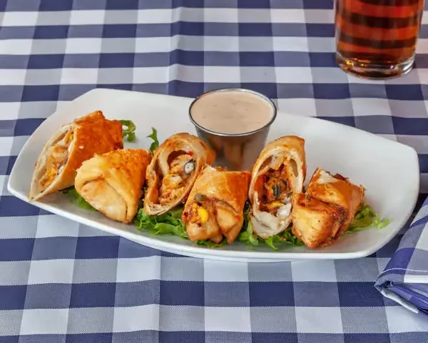 Deep-fried spring rolls or taquitos with chicken, corn, and lettuce.