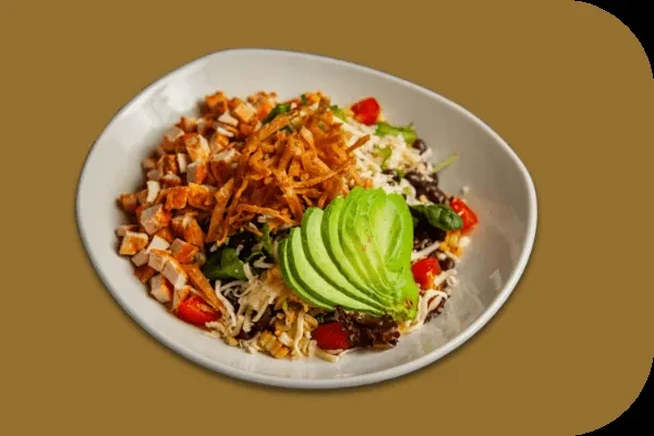 Close-up of a colorful chicken salad bowl with avocado.