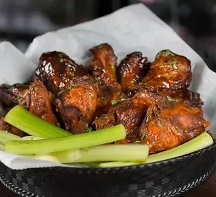 Chicken wings in a basket with celery.