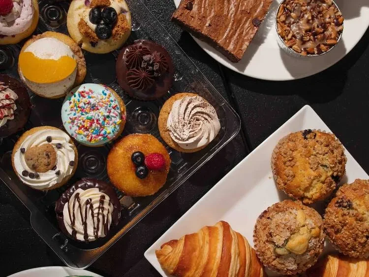 Overhead view of various desserts, cupcakes, brownie, croissant, and muffins.