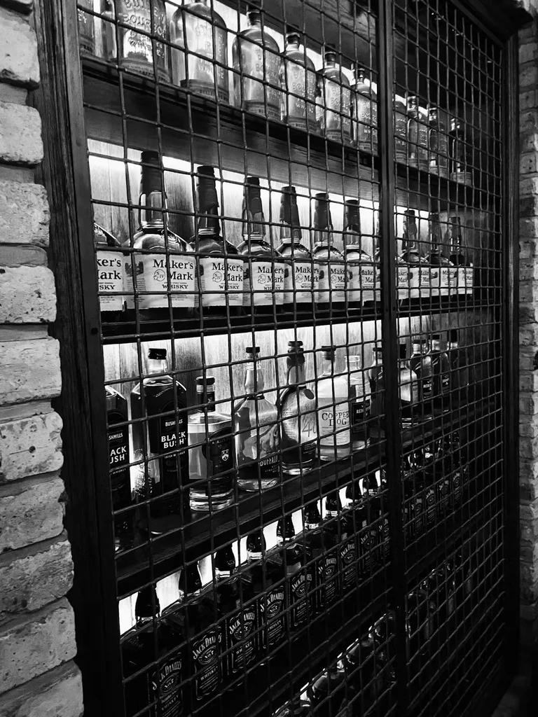 Black and white photo of a well-stocked bar display.