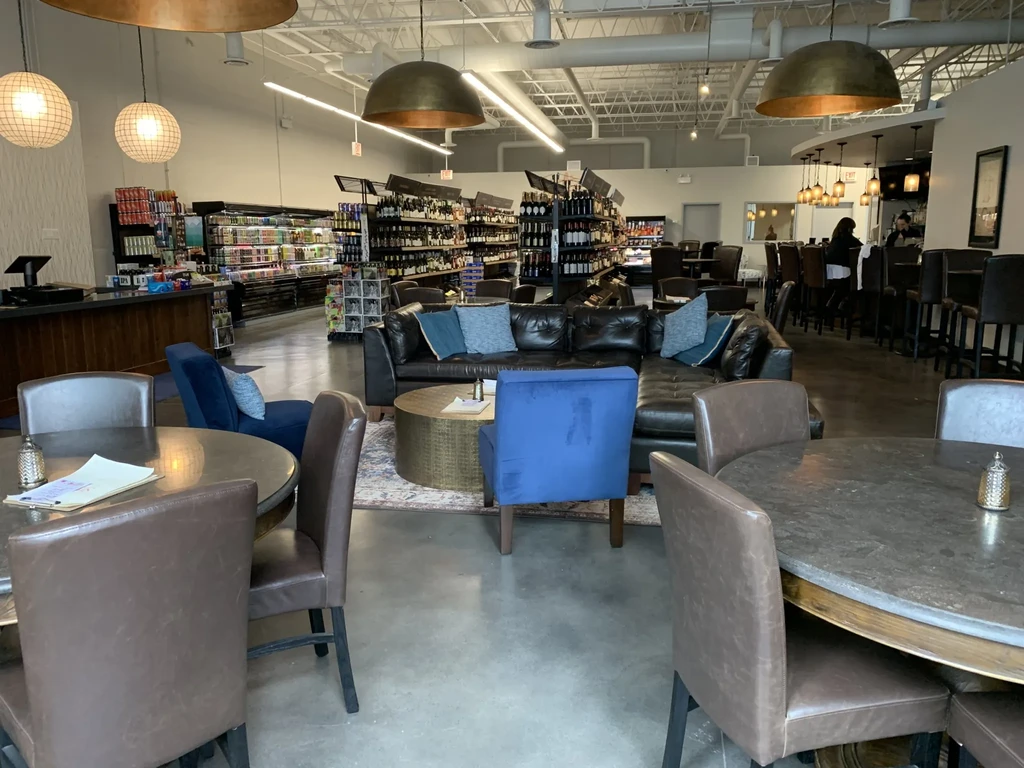An indoor space with a lounge, bar, and retail section.