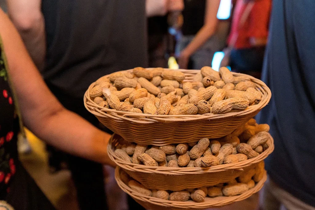Three stacked wicker baskets filled with roasted peanuts.