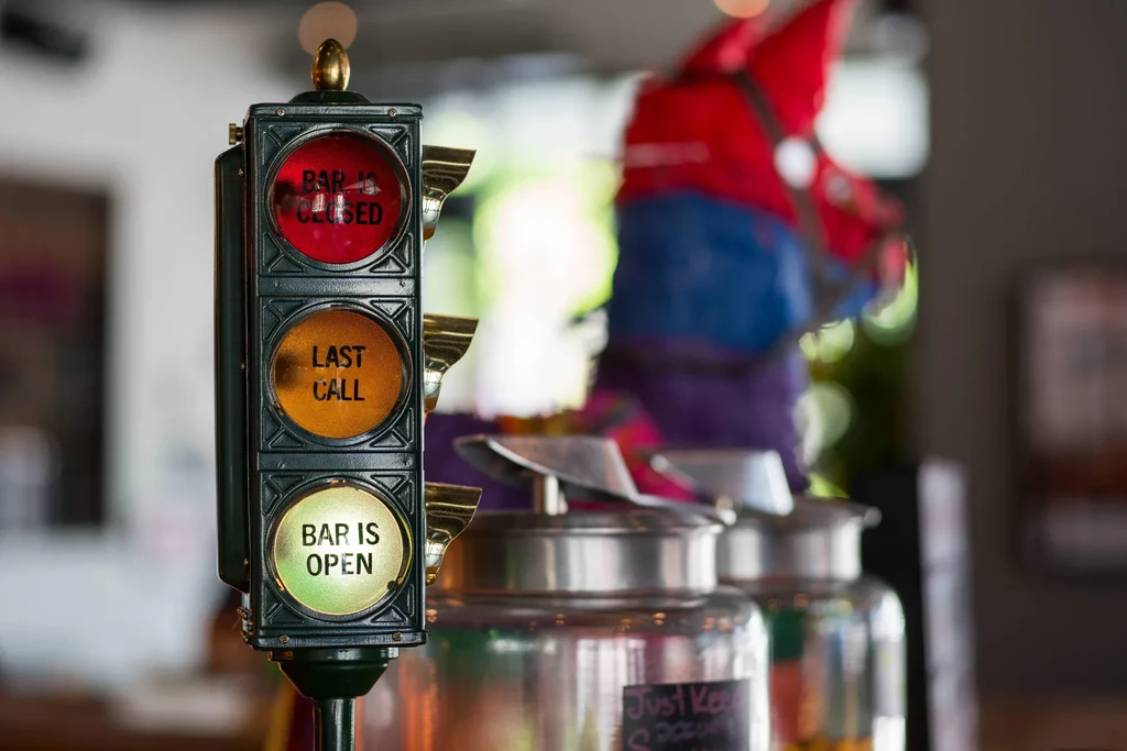 Miniature traffic light indicates "BAR IS OPEN" in a bar setting.