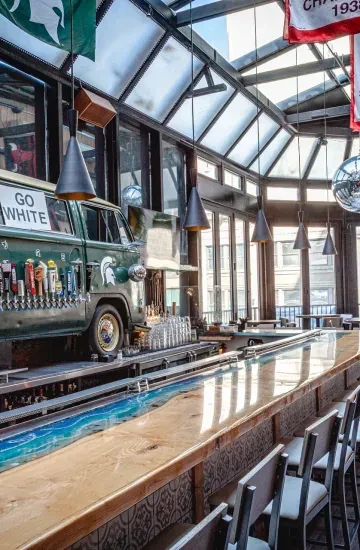 A bar with a blue resin counter and a VW bus tap system.