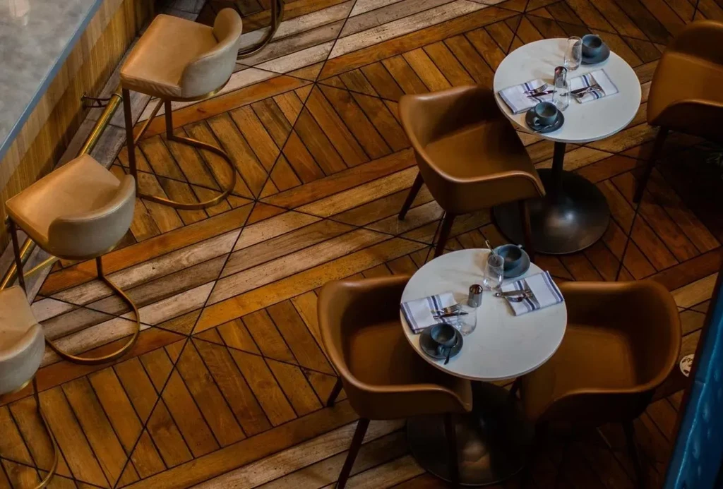 Overhead view of an empty restaurant with wooden floors and seating.