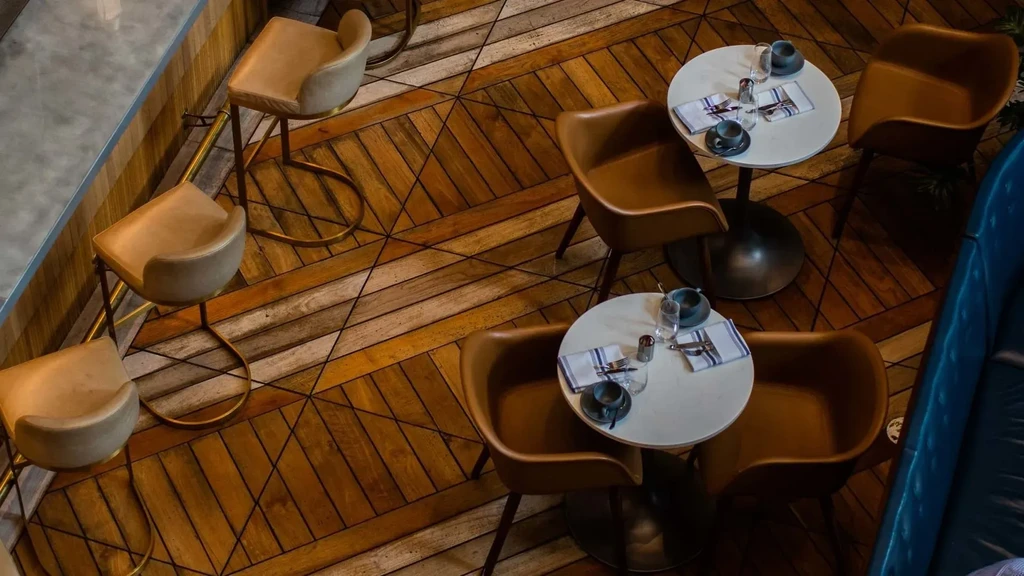 Overhead view of an empty restaurant with geometric wooden flooring.