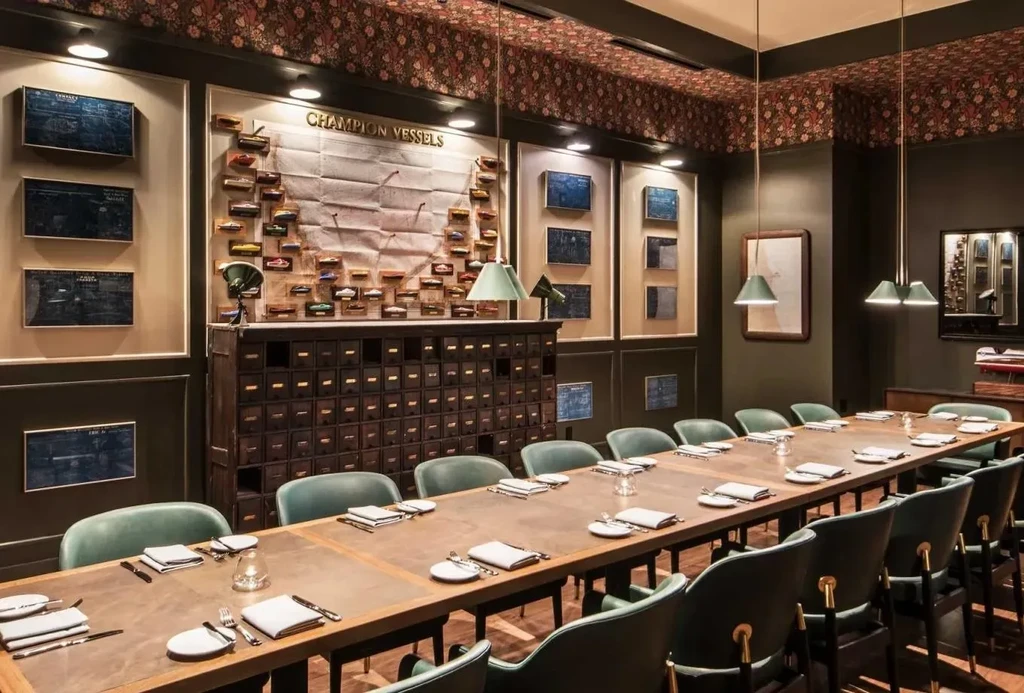 Private dining room with long table, teal chairs, and nautical decor.