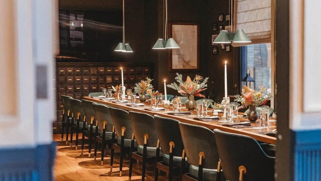 Elegantly set dining table in a private room with floral arrangements.