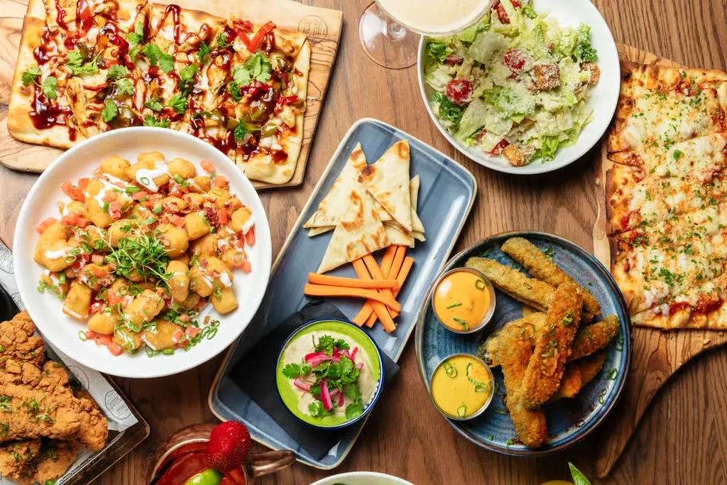 Top-down view of a wooden table laden with various dishes.