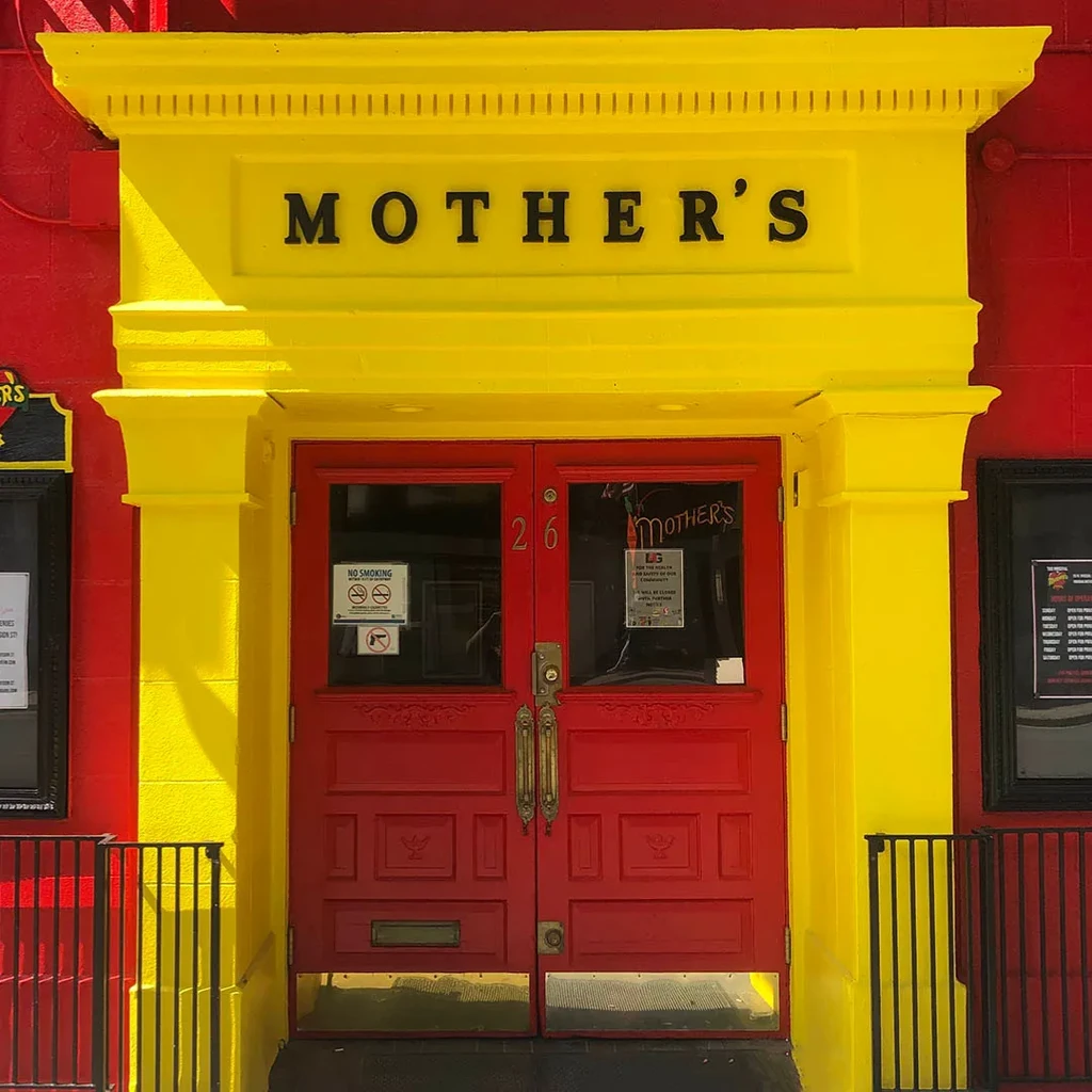 MOTHER'S restaurant entrance with red doors and yellow facade.