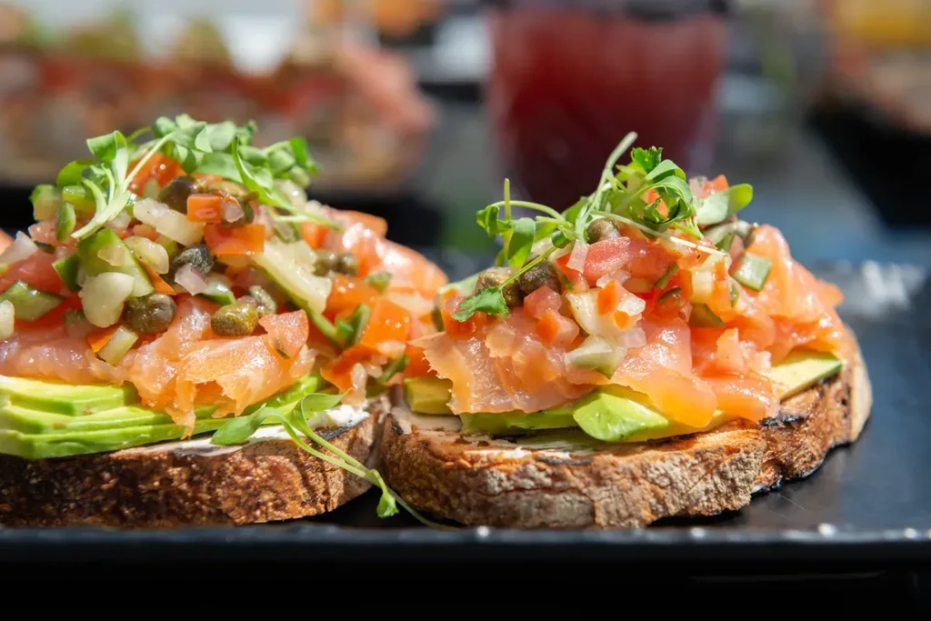 Avocado toast with smoked salmon, salsa, and microgreens.