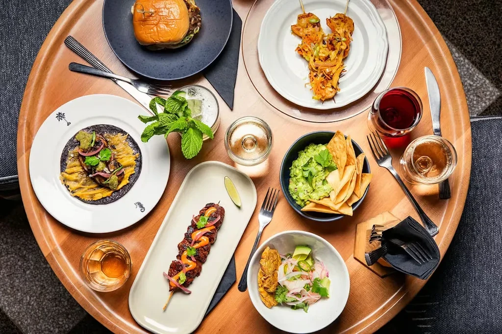 Overhead view of a round table with diverse food and drinks.