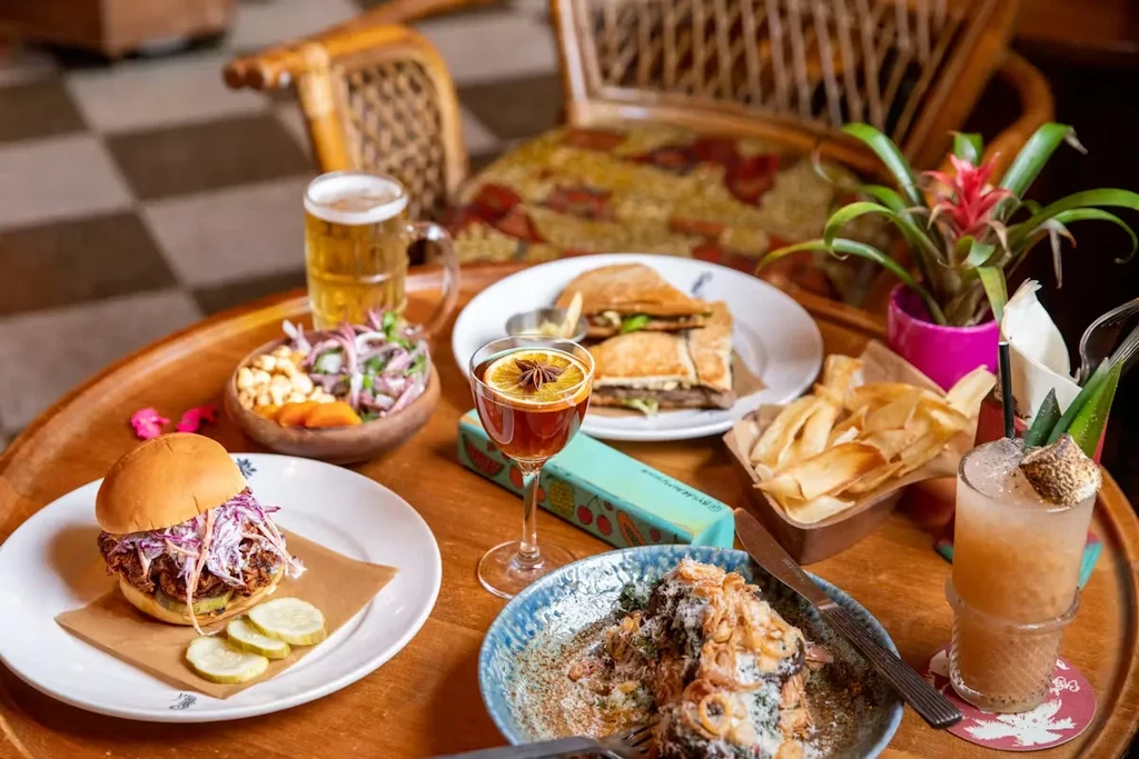 Assortment of food and drinks on a wooden restaurant table.