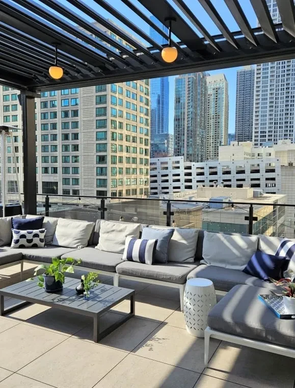 Rooftop patio with L-shaped sofa, coffee table, and city view.