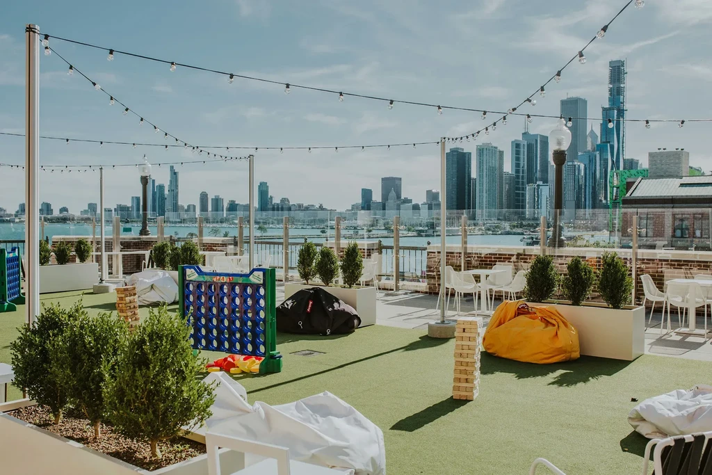 Rooftop patio with games, seating, and city skyline view.