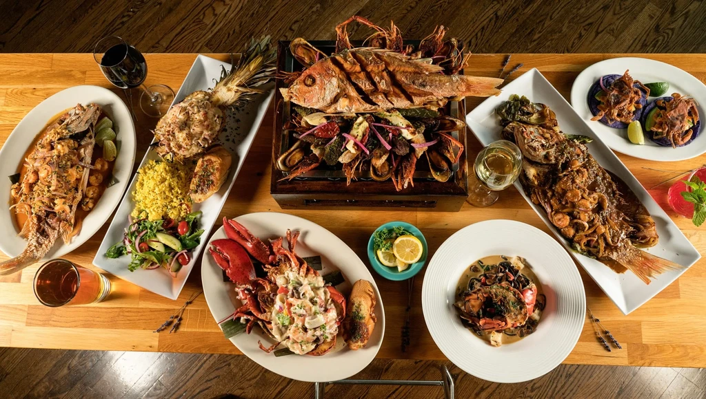 Overhead view of a wooden table laden with an abundant seafood feast.