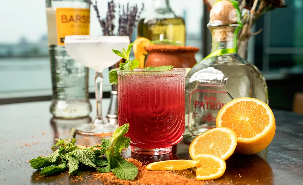 Cocktails and Patrón tequila displayed with mint and orange slices.