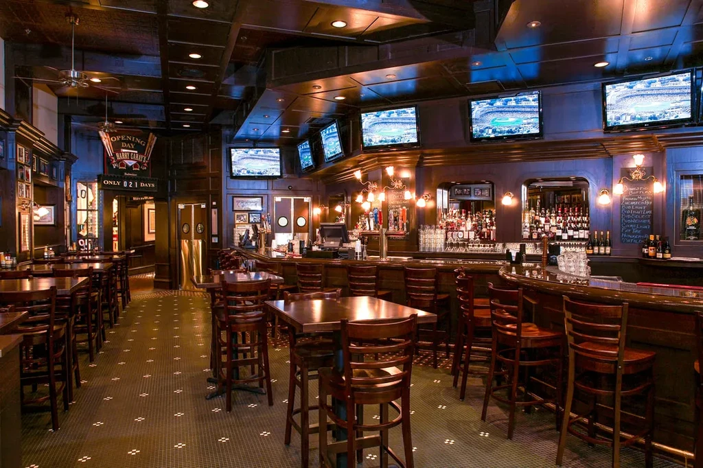 Dimly lit bar with wood accents, TVs, and "OPENING DAY" banner.