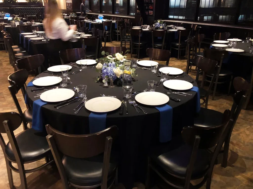 A formal dining table set with flowers, plates, and glasses.