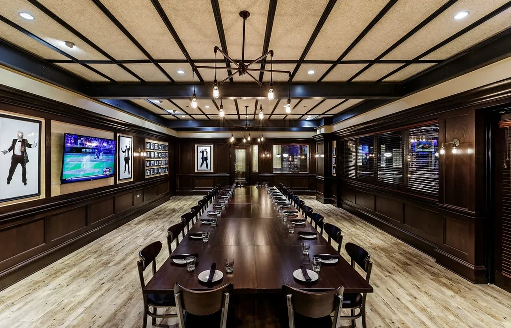 Upscale private dining room with long table and modern chandeliers.