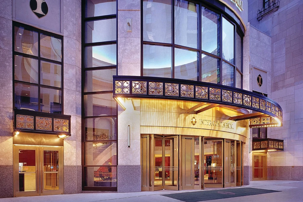 Luxurious building exterior with a grand golden entrance and rotating doors.
