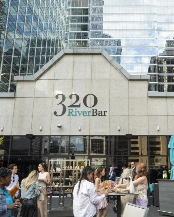 Building with "320 RiverBar" sign and people on a patio.