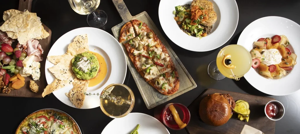 Overhead shot of a table laden with various gourmet dishes and drinks.
