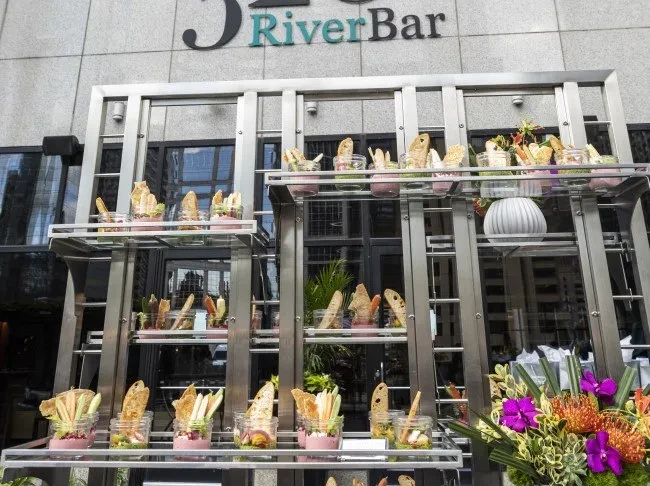 Metallic shelving unit with food jars and flowers at J RiverBar.