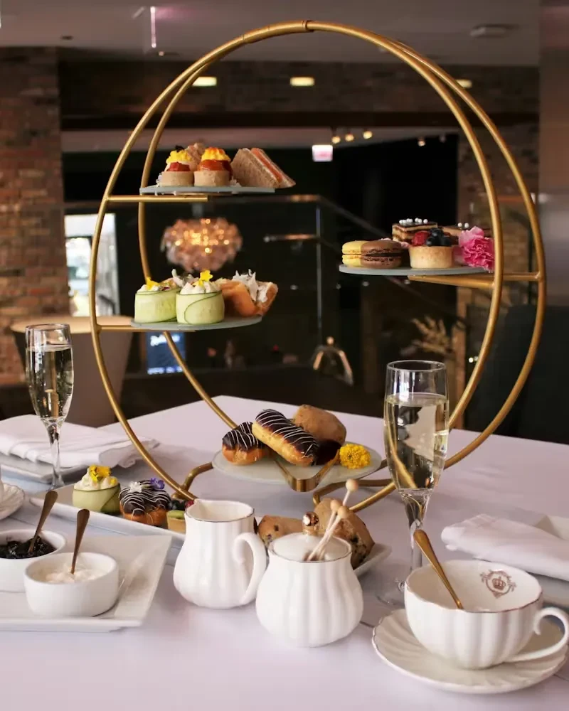 Multi-tiered stand with sandwiches, pastries, and desserts at an elegant tea.