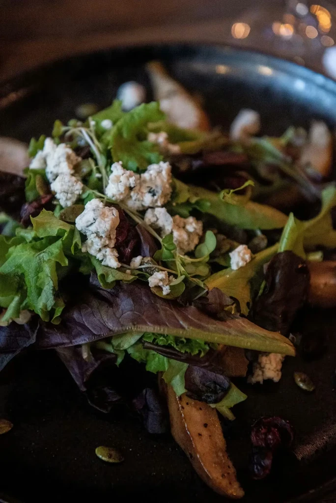 Close-up top-down view of a salad in a dark bowl.