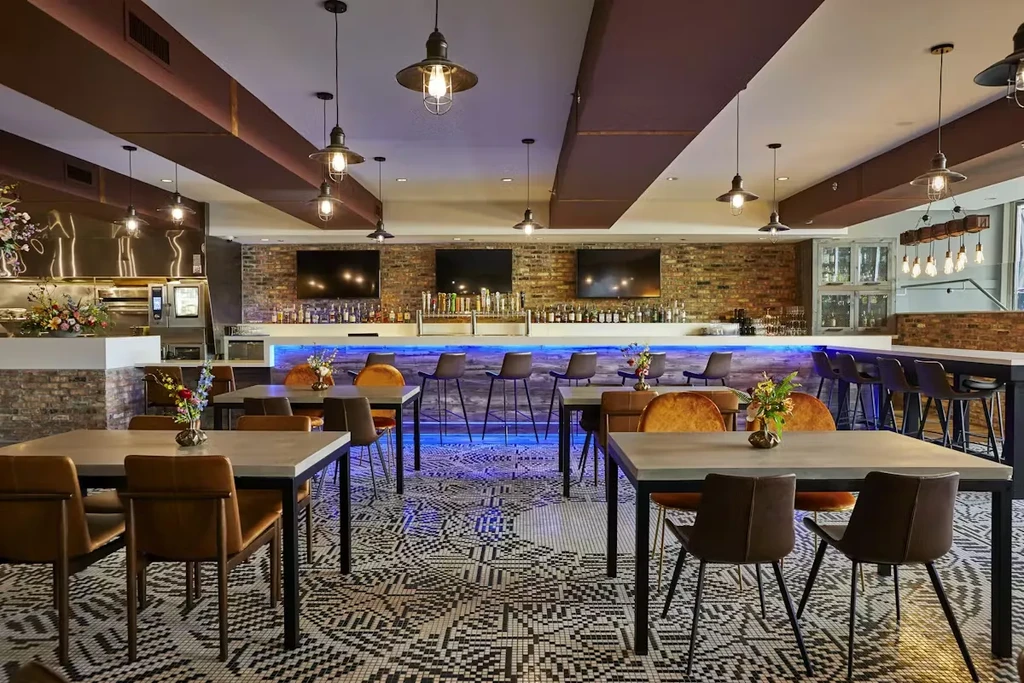 Interior of a modern, empty restaurant with a bar and tables.