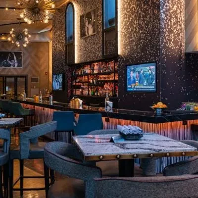 Modern upscale bar or restaurant interior with prominent bar and seating.