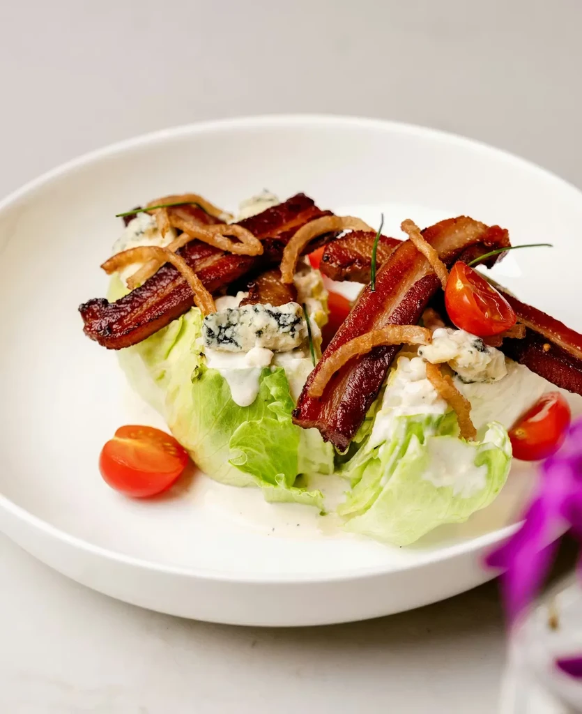 Gourmet wedge salad with blue cheese, bacon, and cherry tomatoes.