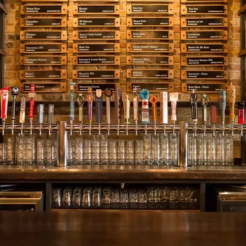 A well-lit bar with a wide selection of beer taps and menu.
