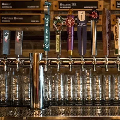 Close-up of several beer taps with distinct handles and names.