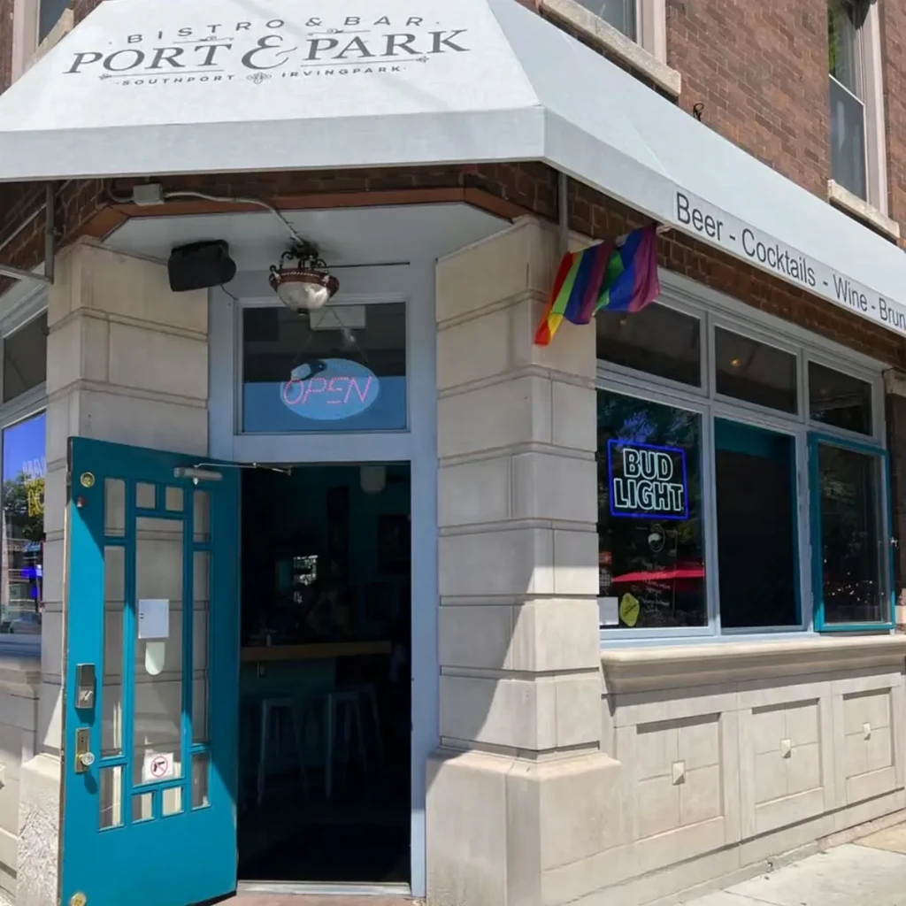 Exterior of Port & Park bistro with teal door and neon signs.