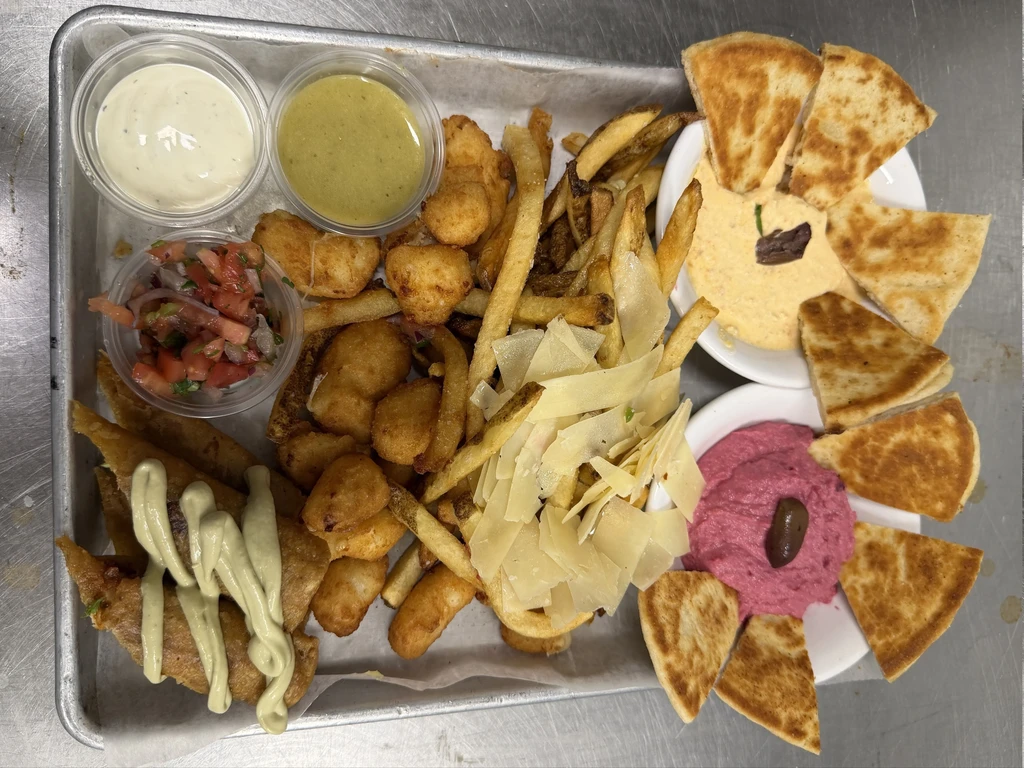 Metal tray of fried foods, pita, hummus, and dips.
