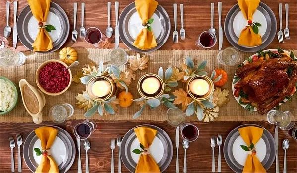 Overhead view of a Thanksgiving dinner table with turkey and autumn decor.