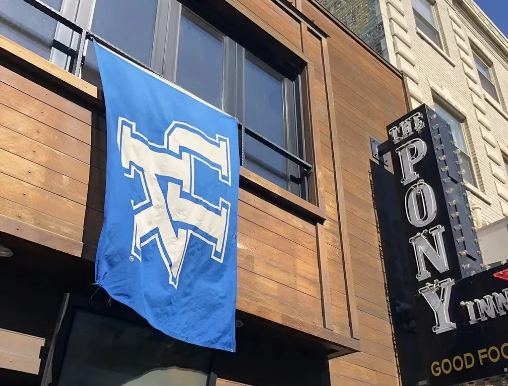Blue flag with 'TC' or 'KC' logo and "THE PONY INN" sign.