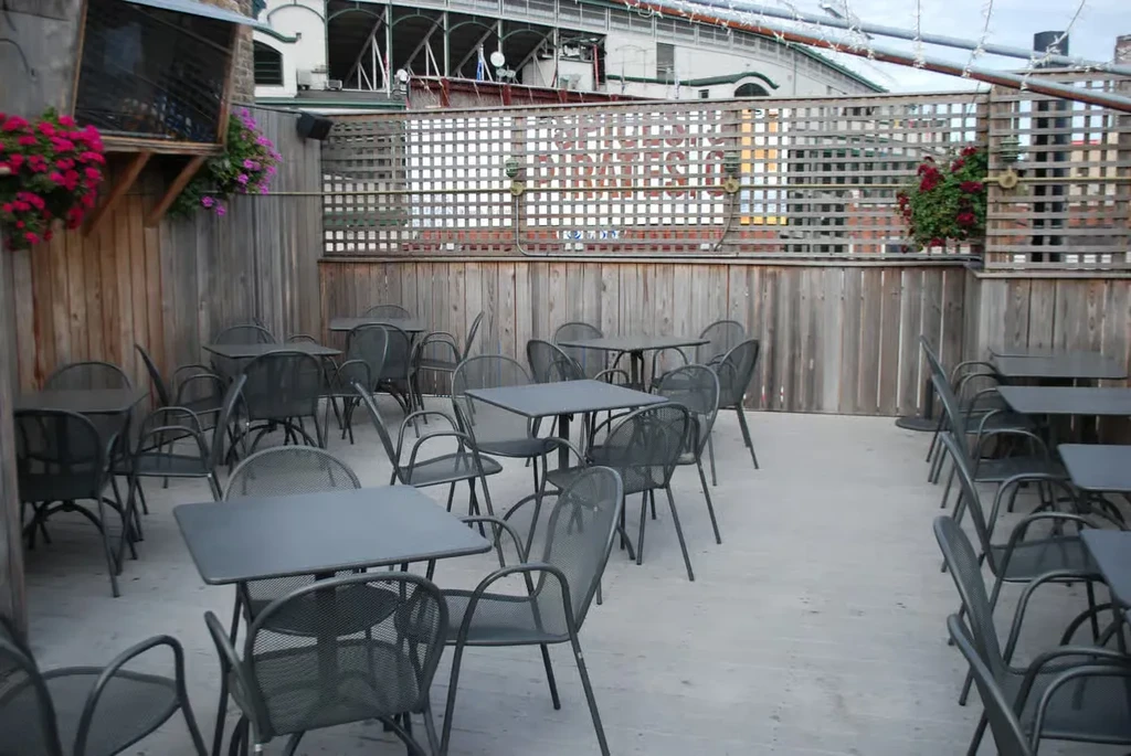 Empty outdoor patio with metal tables and chairs.