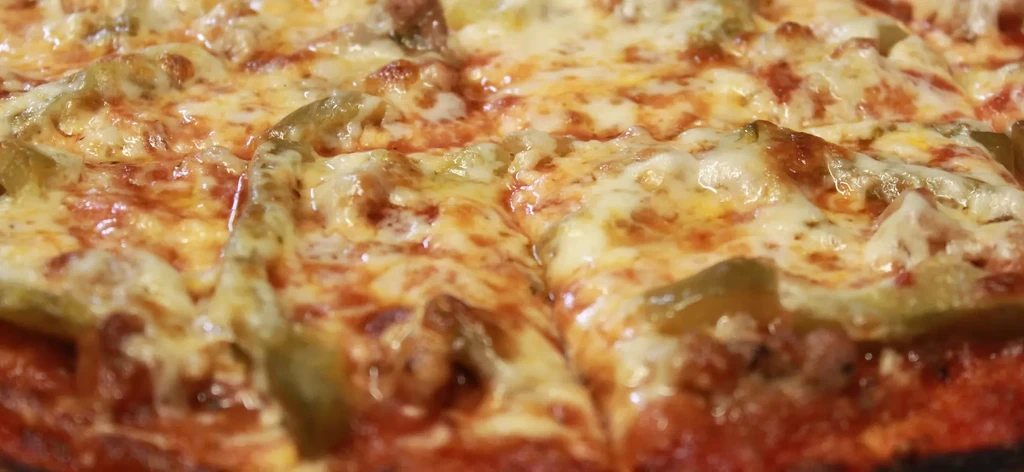 Close-up of a freshly baked pizza with melted cheese and toppings.