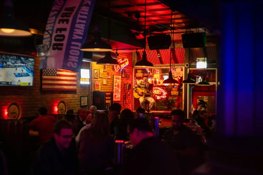Bar with live music, Pabst Blue Ribbon sign, and Penn State banner.