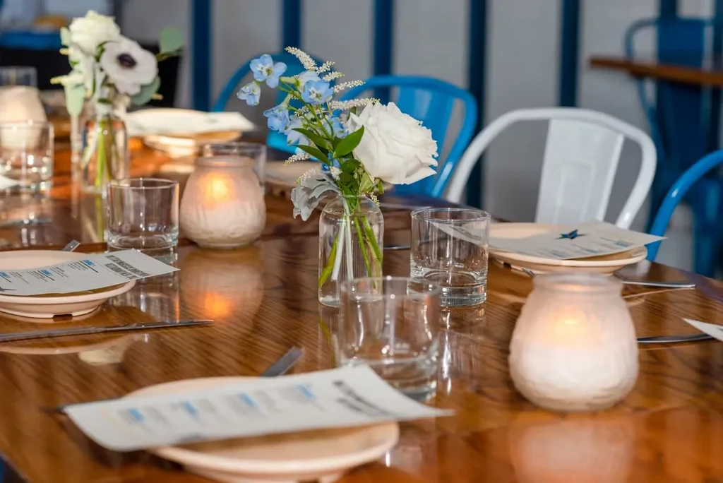 Restaurant table set with flowers, votives, and menus.