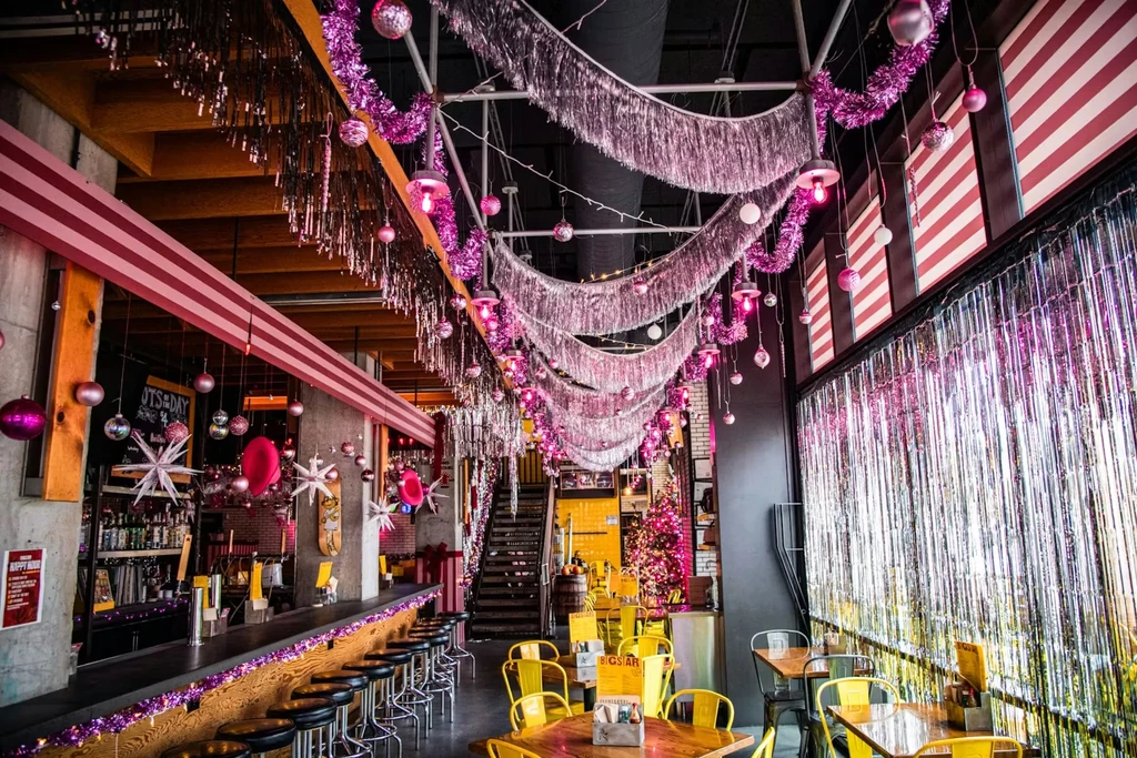 Restaurant interior with abundant pink and silver tinsel and lights.