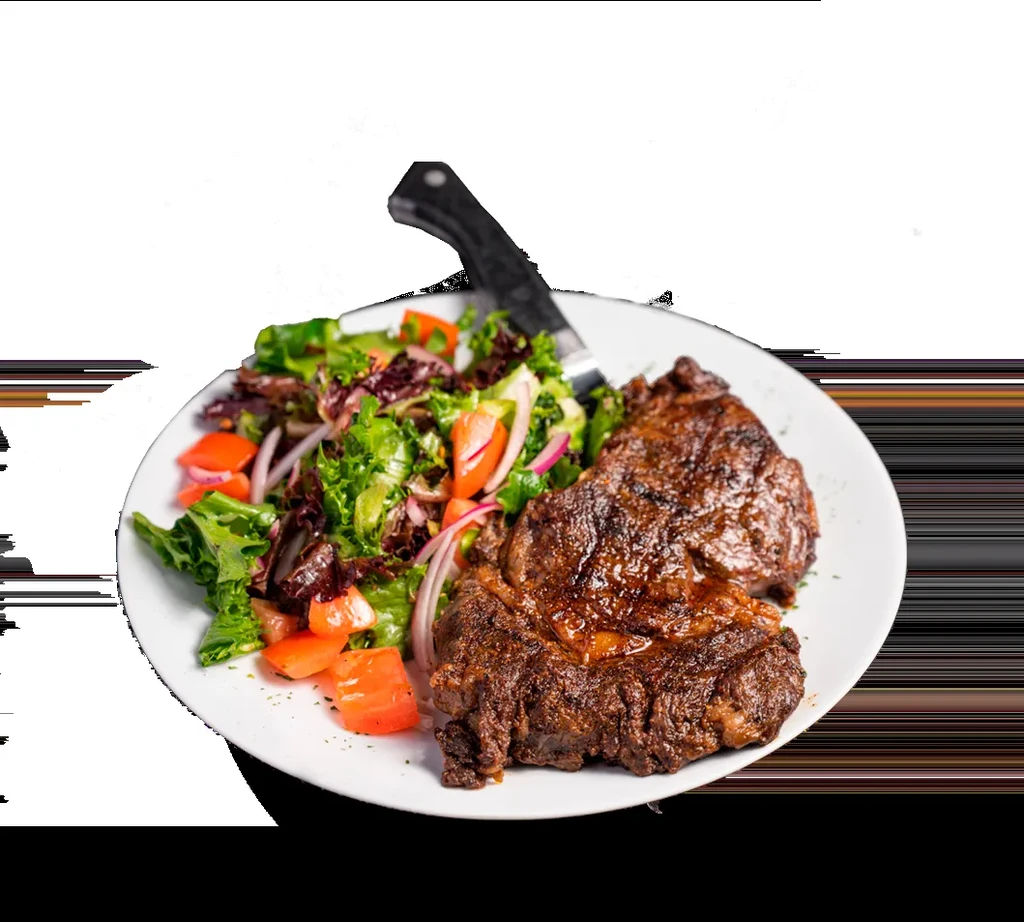 Steak and salad on a white plate with a knife.