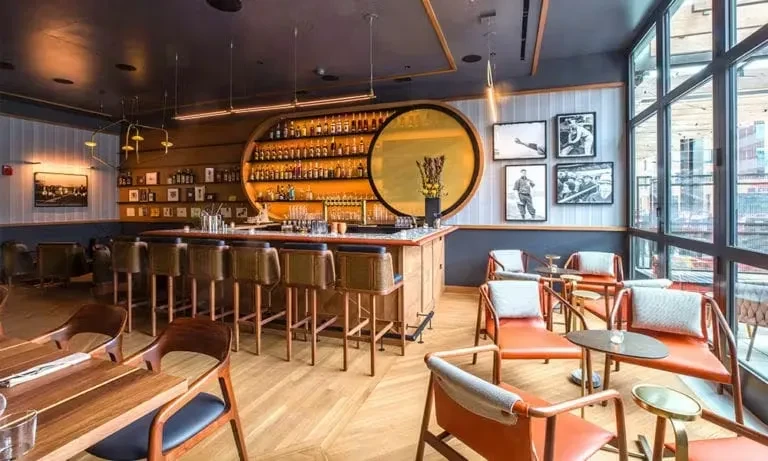 Stylish bar interior with oval liquor display and lounge seating.