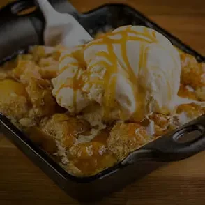 Bread pudding with melting vanilla ice cream and caramel sauce.