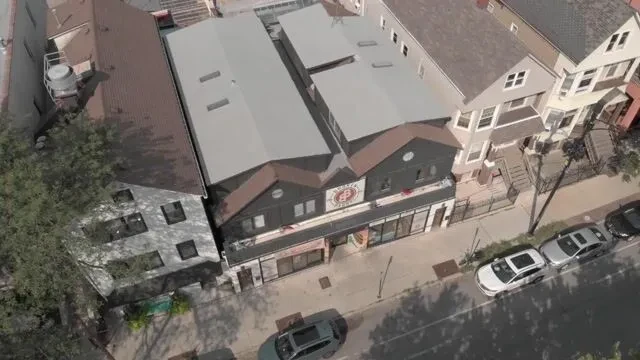 Aerial view of a commercial building with a circular sign and gabled roof.