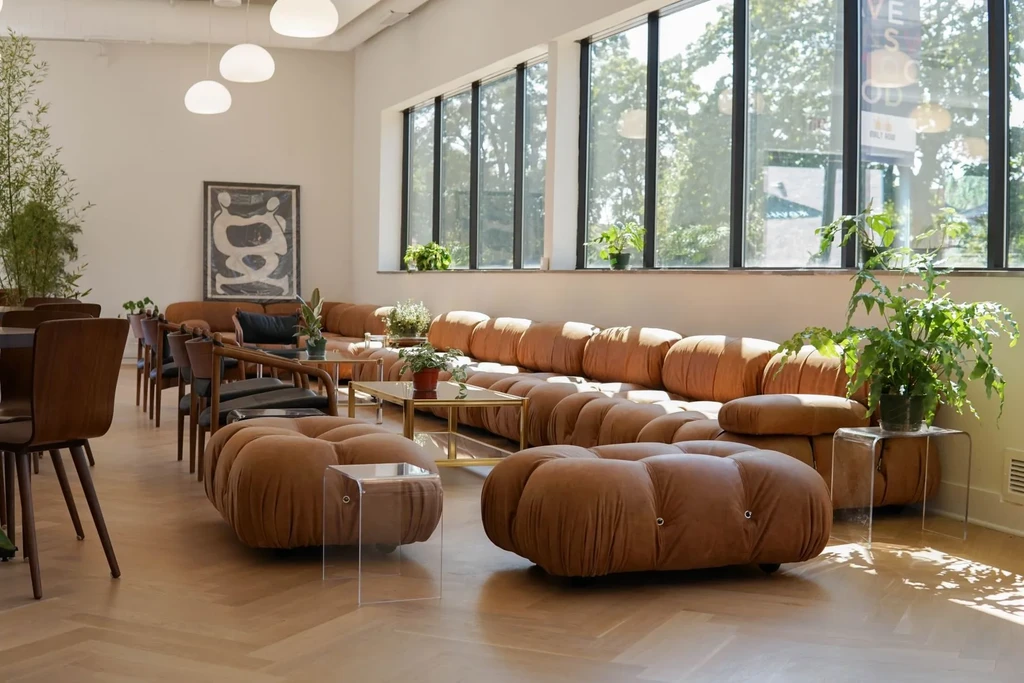 Modern lounge with modular seating, coffee tables, and large windows.